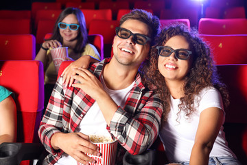 Couple with popcorn watching movie in cinema