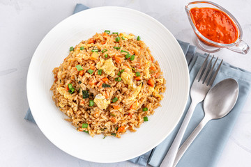 Chinese Fried Rice with Scrambled Eggs and Vegetables Served with Tomato Ketchup on White Background Top View Photo.