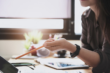 Young woman working with color pencil and notebook and tablet for using design or creative  to...
