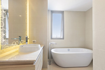 Fototapeta na wymiar Clean and white Bathroom with Amenities in Luxurious Apartments, Bathtub and sink in tolet.