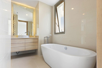 Fototapeta na wymiar Clean and white Bathroom with Amenities in Luxurious Apartments, Bathtub and sink in tolet.