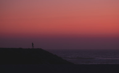 Pessoa na praia ao pôr do sol