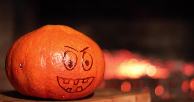 Halloween Pumpkin with a painted face on a background of fire