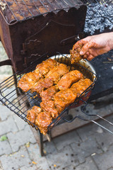 Man puts marinated meat on a metal grid