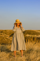 amazing girl in a hat at sunset in the steppe on the sea