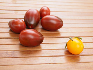Dark red  and yellow tomatoes on wooden surface