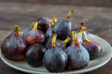 organic figs in a white plate on  wooden background