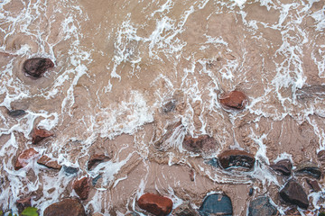 Aerial view of crashing waves on stones View from above, beautiful nature background.