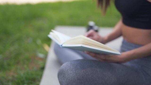 Sporty woman reading handwritten notes outdoors alone, closeup