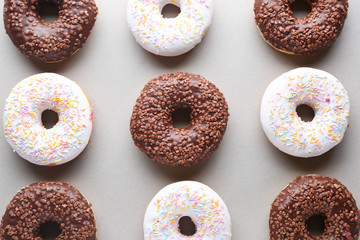 Different tasty donuts on light background
