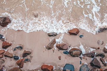 Aerial view of crashing waves on stones View from above, beautiful nature background.