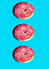Fototapeta premium Creative pattern with pink donuts isolated on blue background. Food photo poster concept. Food flat lay. Creative layout. Food poster.