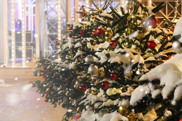 Christmas toys and snow on branch christmas tree. New Year or Christmas, concept, contrast, colorful background. Bokeh effect, copy space. Greeting card template or layout for design.