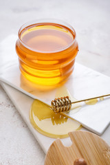 Jar of sweet honey on light background