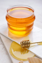 Jar of sweet honey on light background