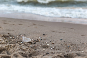 A small plastic cup on the seashore.