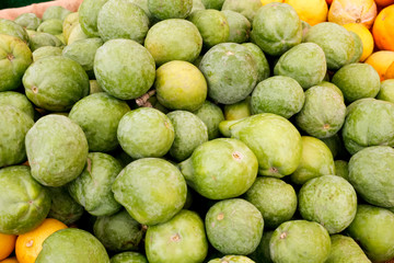 Several guava fruit on display at a local farmers market.