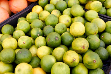 Several limes on display at a local farmers market.