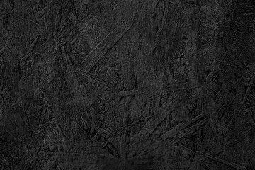 The texture of the wood particle board painted black color.