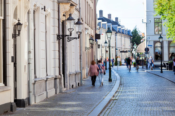 Street with historical buildings and motion blur pedestrians