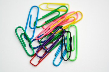 Paper clips of various colors on a white folio