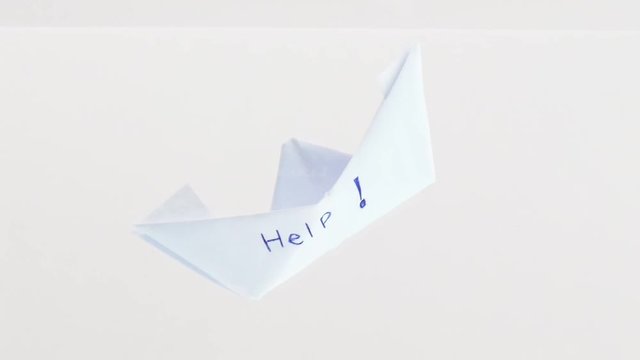 Sinking folded paper boat into the water. Mental state and Emotional concept.