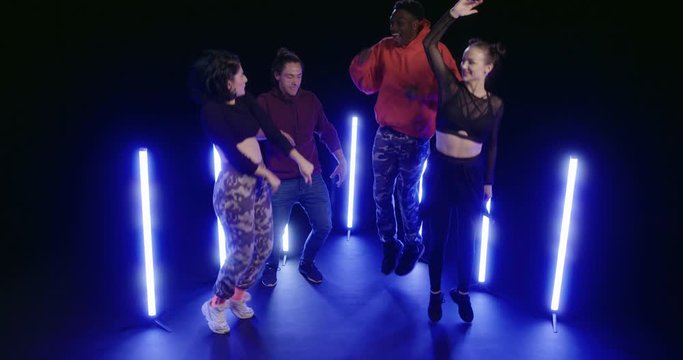 Studio, slow motion, a group of dancers jumping energetically 