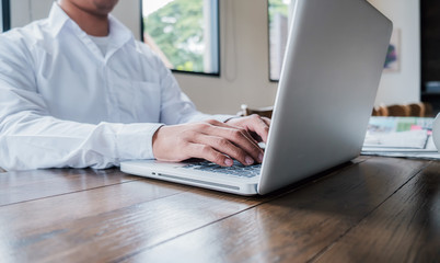 Young unemployed is searching for a job in the newspaper and laptop. Interview the job and hiring concept.