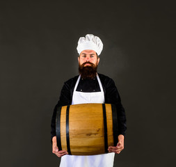 Wooden barrel of beer. Beer in Germany. Bearded cook with wooden barrel of beer. Barman. Equipment for preparate of beer. Brewery for maturing alcohol. Homemade wine. Celebration oktoberfest festival.