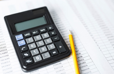 Calculator with pencil on white paper with numbers. Business and Finance accounting concept.