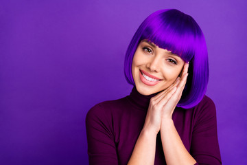 Portrait of cute girl smiling with her palms near cheeks wearing turtleneck isolated over violet...