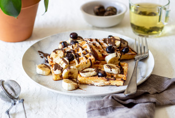 Belgian waffles with blueberries and bananas. National cuisine.