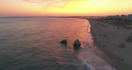 Aerial dusk view of Praia dos Tres Irmaos (Three Brothers beach) in Alvor, famous tourist destination in Western Algarve Coast, Portugal.