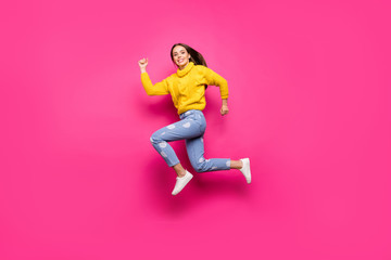Full length photo of lovely girl jumping running wearing yellow pullover dotted denim jeans isolated over fuchsia background