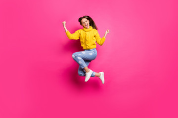 Full size photo of excited girl with her eyes closed jumping raising fists screaming yeah feel lucky wearing yellow dotted denim jeans sweater isolated over fuchsia background - obrazy, fototapety, plakaty