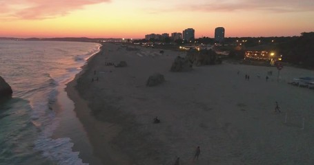 Aerial dusk view of Praia dos Tres Irmaos (Three Brothers beach) in Alvor, famous tourist destination in Western Algarve Coast, Portugal.