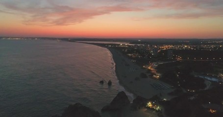 Aerial dusk view of Praia dos Tres Irmaos (Three Brothers beach) in Alvor, famous tourist destination in Western Algarve Coast, Portugal.