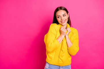 Portrait of charming woman touching her pullover looking isolated over pink background