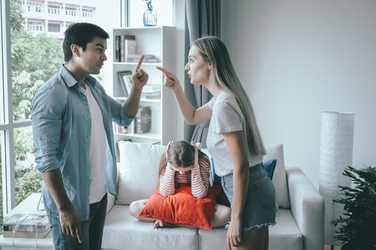 mother and father fighting together and daughter sitting with sad motion at home, young family concept