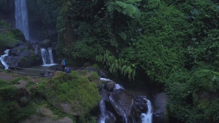 Turists enjoy the view of a waterfall Coban Talun in Java island, Indonesia