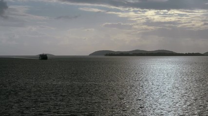 Silhouette of a cruise ship sailing the Mediterranean sea against the background of picturesque mountains at dusk. 4K