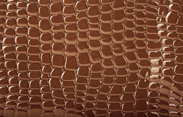 Brown crocodile leather texture, closeup. Useful as background.
