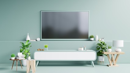 TV on the cabinet in modern living room have plants and book on green wall background.