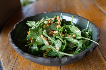 Fresh salad of arugula, pumpkin, apple and pine nut. Vegetarian dish of greens with nuts. Appetizing salad with natural and organic products. Photo salad for a menu in a restaurant