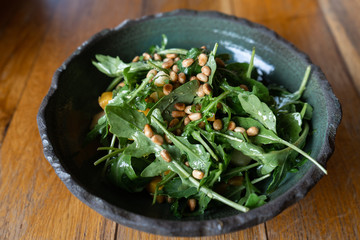 Fresh salad of arugula, pumpkin, apple and pine nut. Vegetarian dish of greens with nuts....
