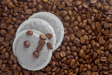 stack of coffee pods on coffee beans