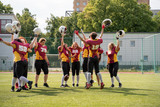 Full length image of woman rugby team with raised hands looking at camera