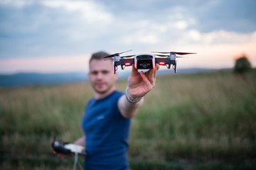 The young man manipulates the drone using the control panel. New technologies and trends in photo...