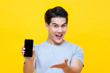 Smiled young good looking Asian guy showing smartphone