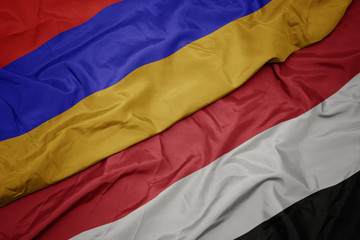waving colorful flag of yemen and national flag of armenia.